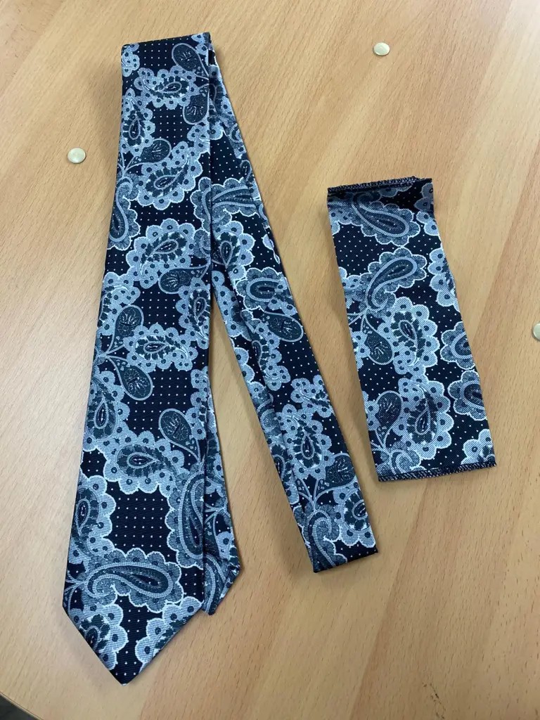 Cravate et pochette à motif paisley sur table en bois